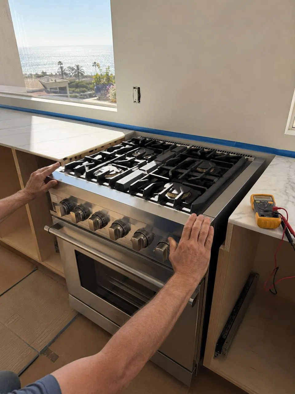 Repairing stainless gas range cooktop in an oceanview Southern California kitchen
