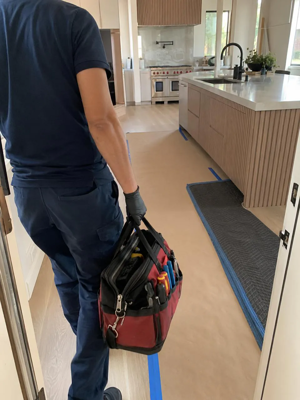 Appliance technician arriving with tool bag at a Southern California home