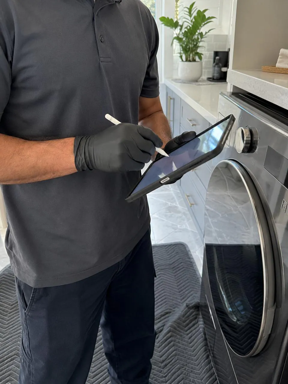 Technician inspecting front-load washer on a tablet in Southern California laundry